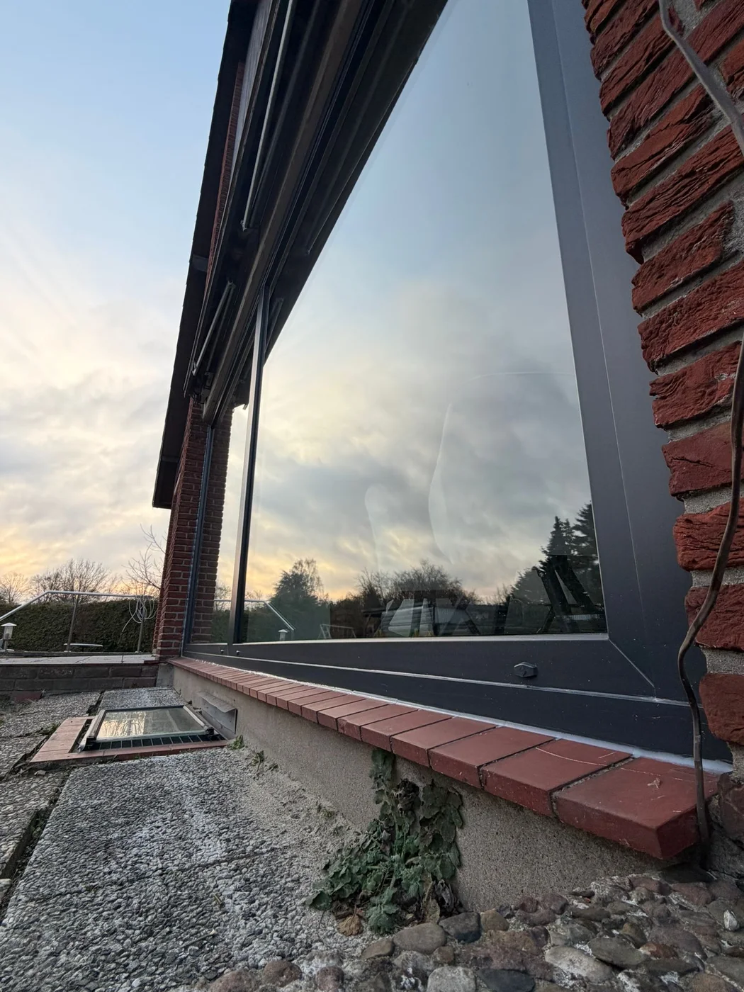 Große Fensterfront mit schlanken Rahmen im Abendlicht